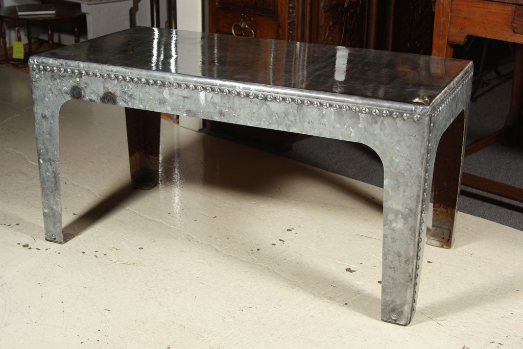 Galvanized water tank table with rivets and highly polished.